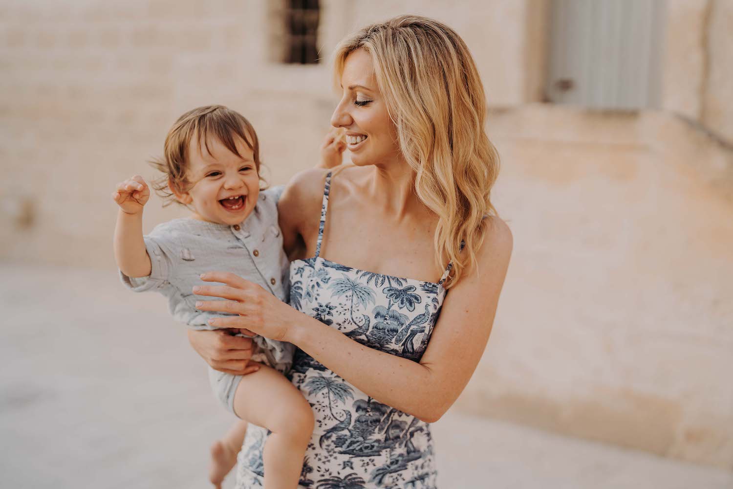 Mother holding laughing baby at Borgo Egnazia 